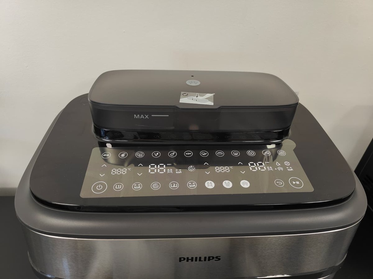 Bovenkant van de Philips Airfryer 5000 met het waterreservoir en het glanzende touchscreen met de knoppen voor beide manden