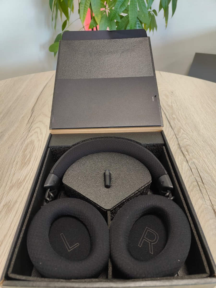 Razer Kraken V4 in de geopende binnendoos, met de USB-C-dongle in het midden